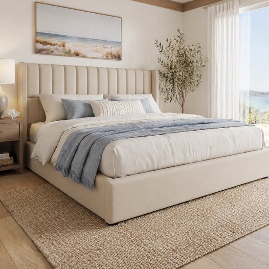 Beige gestoffeerd tweepersoonsbed met gestreepte hoofdsteun, opgemaakte bedden met blauwe en witte accenten. Een plant staat aan de rechterkant.