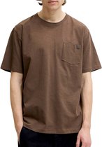 Man met handen in zakken draagt een bruin T-shirt met borstzakje.