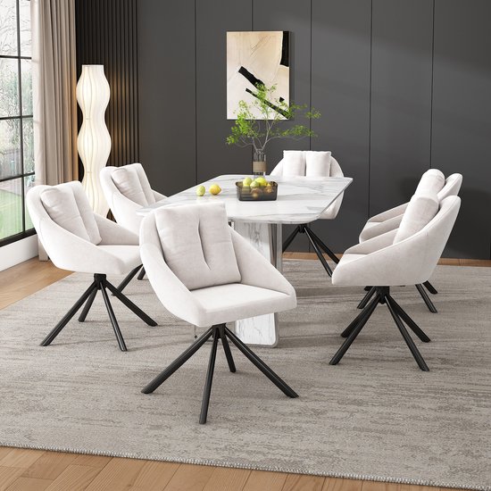 Zes beige fluwelen eetkamerstoelen met zwarte poten rond een marmeren eettafel.