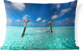 Sierkussen Hangmat op het strand voor buiten - Een hangmat die omringd is door het lichtblauwe water - 50x30 cm - rechthoekig weerbestendig tuinkussen / tuinmeubelkussen van polyester