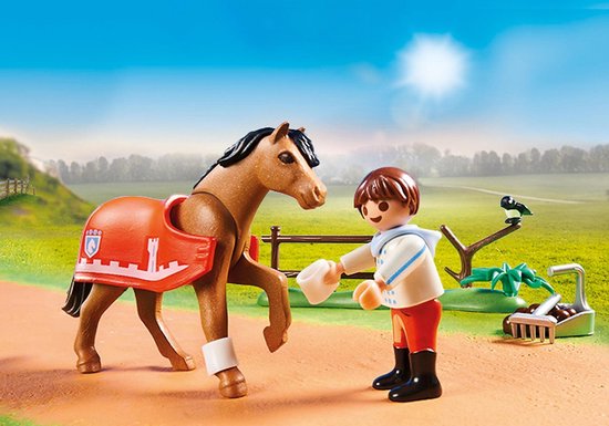 Cheval Playmobil marron avec couverture orange et blason, à côté d'un garçon en veste blanche et pantalon rouge.