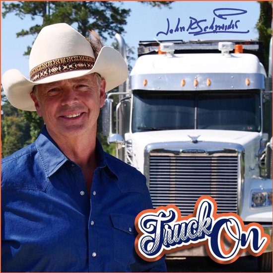 Een man met een witte cowboyhoed, blauw denim overhemd, lacht voor een witte vrachtwagen. "Truck On" logo.