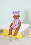 Babypop met paarse muts met oortjes en paars-roze rompertje met teddybeerhart, zittend.