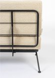 Beige bouclé bank met een zwart metalen frame en poten op een witte achtergrond.