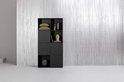 Armoire noire dans un salon, avec des décorations dans les compartiments ouverts.