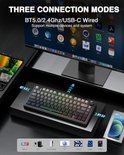 Zwart mechanisch toetsenbord met RGB-verlichting, aangesloten via Bluetooth en USB-C, met icoontjes van apparaten.
