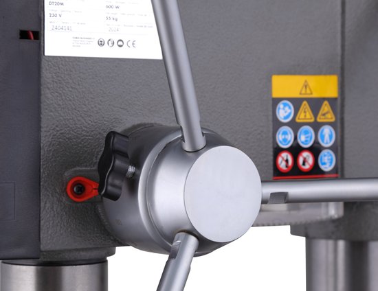 Grijze boormachine met 3 metalen hendels en een zwarte instelschroef.