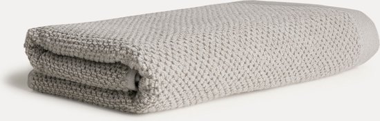 Grijze badstof handdoek met een wafelpatroon, opgevouwen.