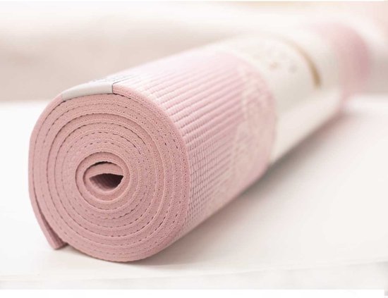 Gedetailleerd deel van een opgerolde roze Love Generation yogamat met een wit, textuurachtig patroon.