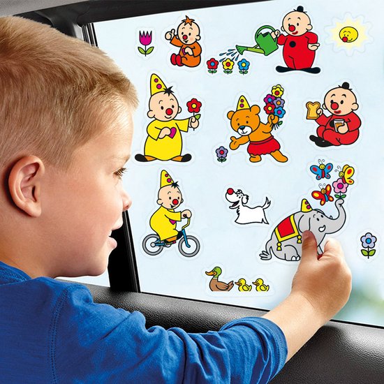 Jongen plakt raamstickers met Bumba, clowns, beer, hond, olifant en kuikens op het raam.