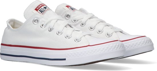 Paar witte lage Converse All Star sneakers met rode en blauwe accentstrepen op de zool.