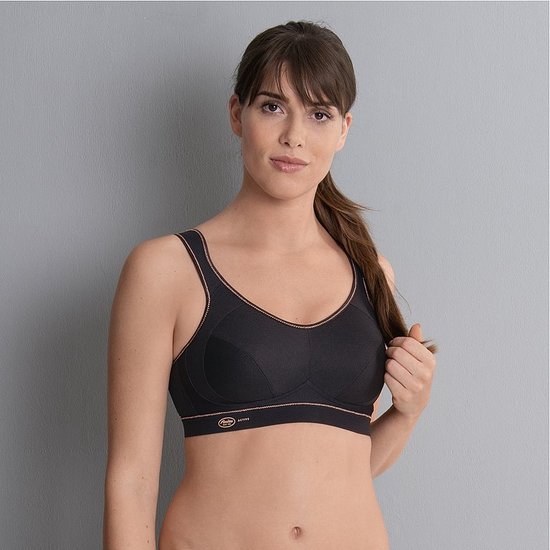 Model van voren in zwarte sportbeha met koperkleurige biezen en Anita Active logo.