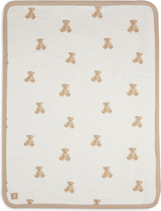 Couverture bébé blanche avec un imprimé all-over d'ours en peluche marron et un passepoil marron. En bas à gauche, une étiquette 'Jollein'.