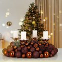 Koperbruine kerstballen met glitter en patronen, omringen een zilveren kandelaar met vier brandende witte kaarsen.