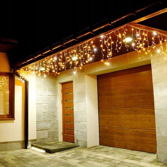 Gouden icicle lichtslinger boven een garagepoort en voordeur.