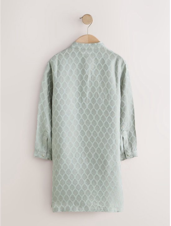 Achterkant van een lichtgroene kurta met bladpatroon, hangend aan een kledinghanger.