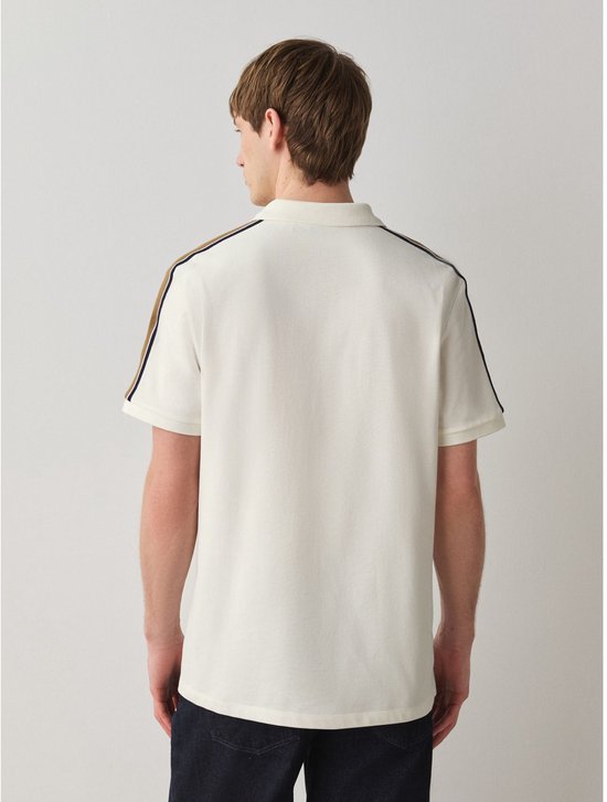 Crème poloshirt met strepen op de schouders en mouwen, gedragen door een man op een witte achtergrond.
