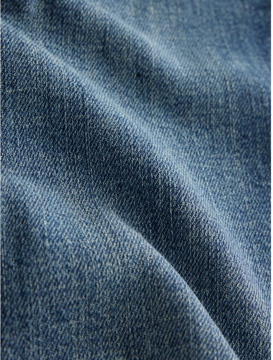 Textuur van blauwe denim stof met duidelijke weefpatronen.