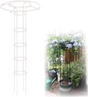 Witte, opengewerkte plantensteun naast een zwarte plantensteun met blauwe bloemen, een gieter staat op de achtergrond.