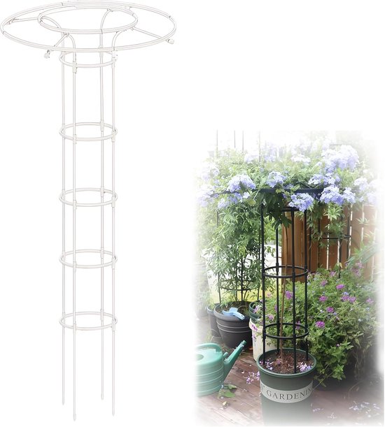 Witte, opengewerkte plantensteun naast een zwarte plantensteun met blauwe bloemen, een gieter staat op de achtergrond.