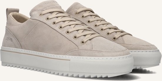 Close-up van crème suède lage sneakers met beige veters en dikke witte zool.