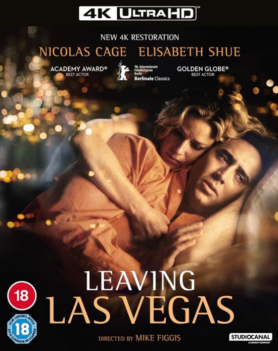 Nicolas Cage en Elisabeth Shue omhelzen elkaar, met op de achtergrond bokeh lichten. "Leaving Las Vegas" 4K Ultra HD.