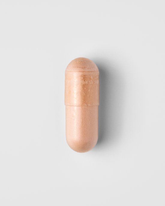 Een enkele lichtoranje capsule met een donkere ring in het midden.