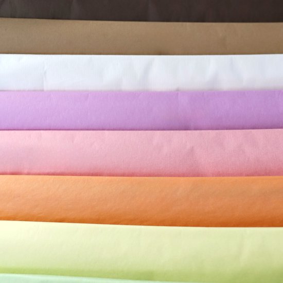 Stapel gekleurd vloeipapier: bruin, wit, lila, roze, oranje en lichtgroen.