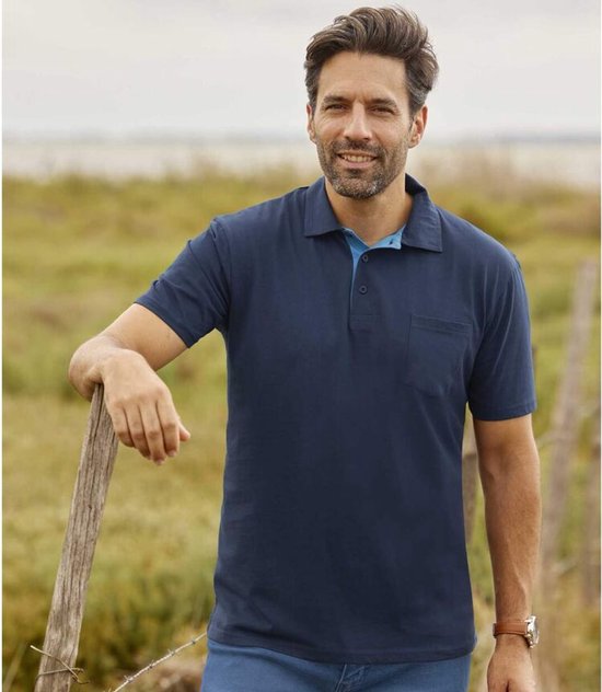 Man met marineblauw poloshirt met korte mouwen, borstzakje en lichtblauwe kraag.