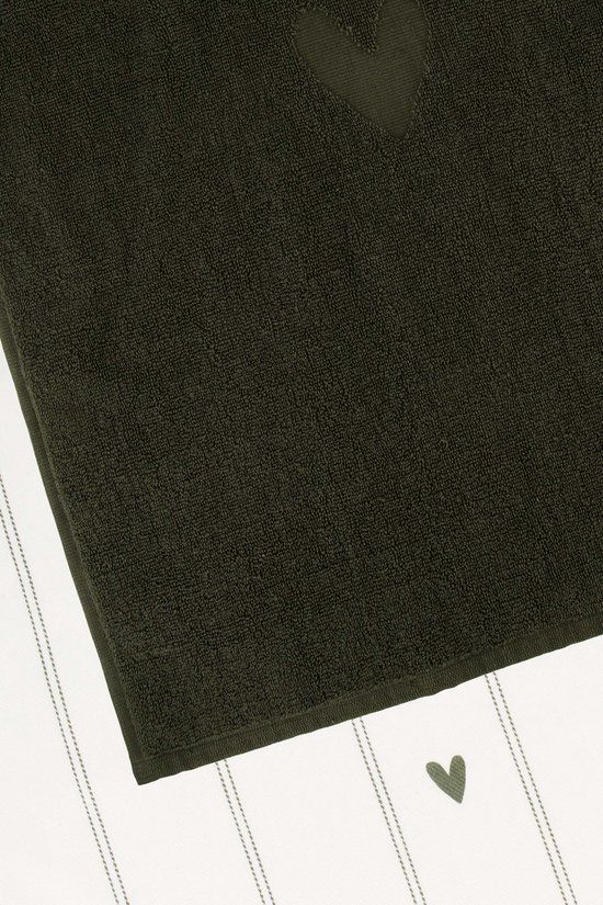 Close-up van een donkergroene keukendoek met hartje, liggend op een witte keukendoek met strepen en hartje.