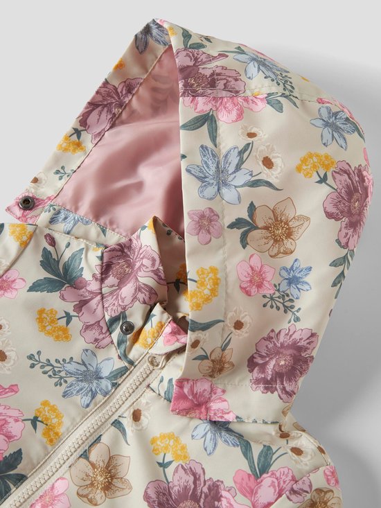 Detail van de capuchon van een beige jas met een bloemenprint in roze, paars, blauw en geel.