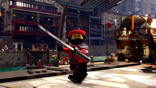 Een rood met zwarte Lego-ninja met masker en zwaard in een stedelijke omgeving met gebouwen en water.