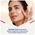 Vrouw met gebruinde huid brengt witte crème aan op haar wang. Krachtige 2-in-1 formule.
