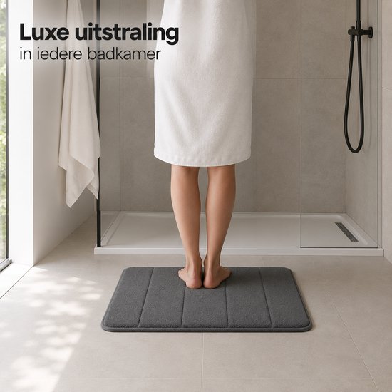 Tapis de bain gris côtelé, vu du point de vue de quelqu'un debout dessus après une douche.