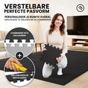 Vrouw houdt een zwarte insteekmat vast, met inzetstukken die 2 kleuren laten zien: grijs en zwart.