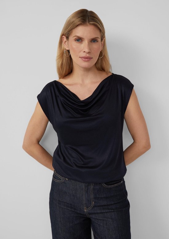 Vrouw met blonde haren in donkerblauw T-shirt met boothals.