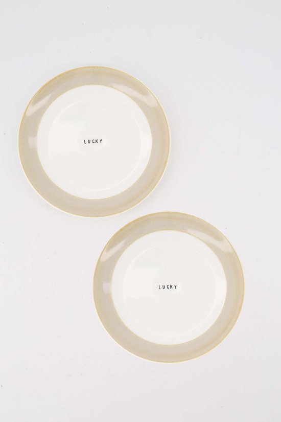 Twee witte gebaksbordjes met een beige rand en 'LUCKY' in het midden.