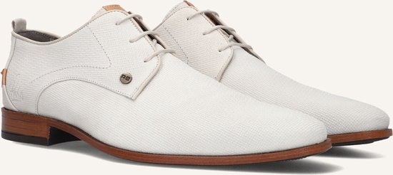 Paar witte veterschoenen met bruine zool.
