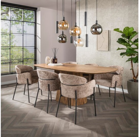 Salle à manger avec une table en bois, entourée de six fauteuils couleur champagne à dossier rond.