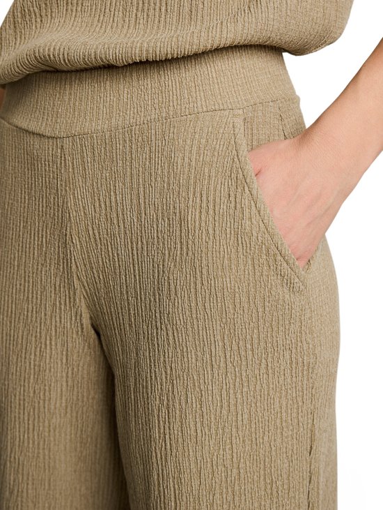 Detail van de beige culottebroek met crinkle textuur en een steekzak.