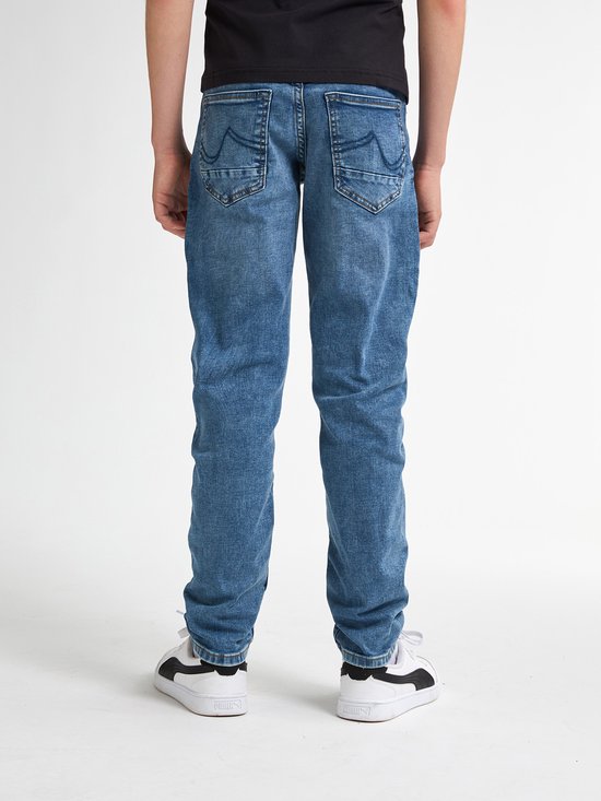 Achterkant van een blauwe jeans. De jeans heeft opgestikte achterzakken met een decoratieve naad.