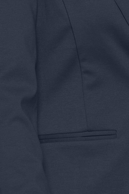Gedetailleerde close-up van de textuur en het borstzakje van een donkerblauwe blazer.