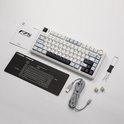 Wit mechanisch toetsenbord met accessoires, waaronder een handleiding, polssteun en USB-kabel.