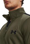 Close-up van de kraag van een groen trainingsjack met een ritssluiting en een zwart Under Armour logo.