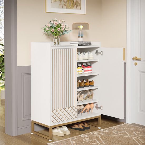 Witte schoenenkast met gouden lijnen, open deuren tonen schoenen. Staat op een gangvloer met tapijt.