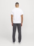 Zijaanzicht van een man van achteren, met een wit t-shirt en donkergrijze joggingbroek.