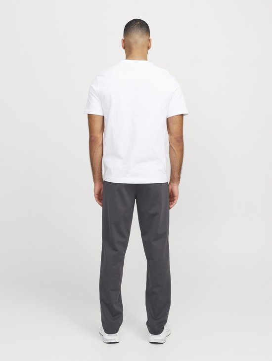 Zijaanzicht van een man van achteren, met een wit t-shirt en donkergrijze joggingbroek.