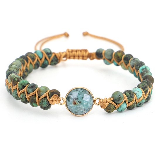 Armband met groene Afrikaanse turkoois kralen, gevlochten op goudkleurig koord, met een centraal rond facet geslepen edelsteentje.