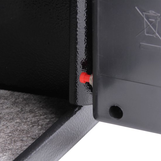 Detail van de binnenkant van een zwarte kluis met een rode knop en een grijze voering.