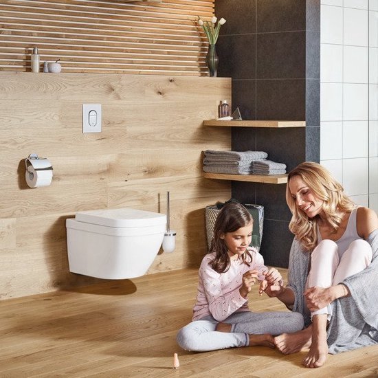 Mère et fille dans une salle de bain avec WC suspendu et porte-brosse WC. Murs en bois.